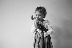 Black and white photo of the girl with the teddy bear on her hands