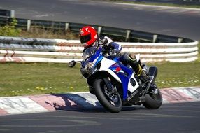 motorcyclist in a red helmet on the track