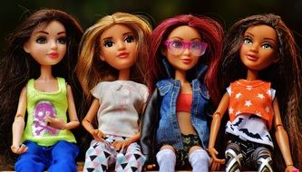 Four dolls on a park bench