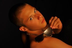 photo of a young man with sunglasses on a dark background