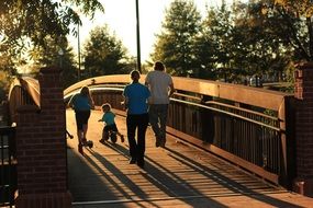 family on a wooden bridge at sunset