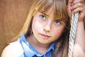 girl with blue eyes holds on to the rope