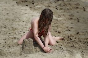 Child girl making sand tower on Beach