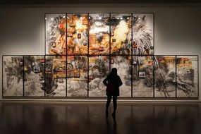 silhouette of a man at an exhibition of paintings in a museum