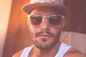 young man in a fashionable cap and sunglasses