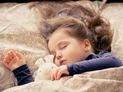 baby girl sleeping with a plush bunny