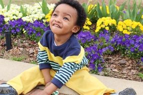 african child near flower bed