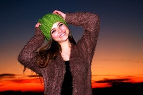 charming girl in a green hat at sunset