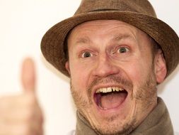 happy adult man in hat with thumb up