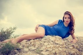 model in blue dress posing on stones