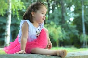 baby girl sitting on a concrete slab