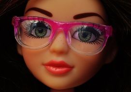 a beautiful doll with glasses rimmed with pink closeup