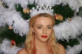 blonde with a crown on the background of the Christmas tree