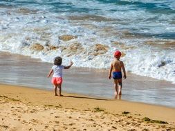 small children on the yellow sand on the beach
