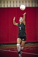 boy in black uniform plays volleyball