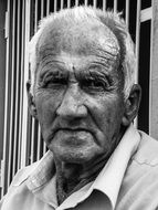 Black and white portrait of the man near the fence