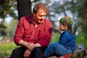 mature Man Looking at child boy sitting outdoor