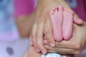 legs of a small child in the arms
