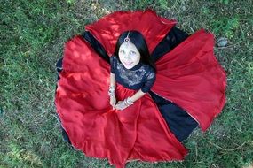 Indian girl in red-black dress on the grass