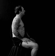 sitting man in tattoos in profile