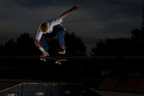 man jumping on a skateboard in the dark