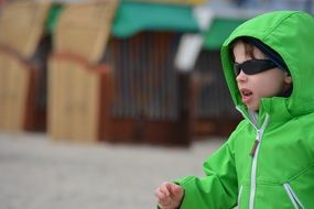 child in a green jacket in profile