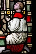 image of a praying man on a stained glass window of a church