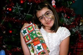 girl with a big gift near the Christmas tree