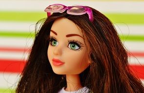 doll with brown hair and glasses on his head