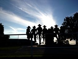 silhouettes of cowboys at sunset