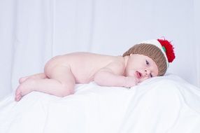 Portrait of cute newborn baby on a white bed