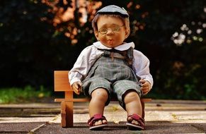 doll with glasses on the bench in the park