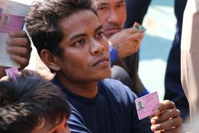 group of dark skin men with identity cards in hands