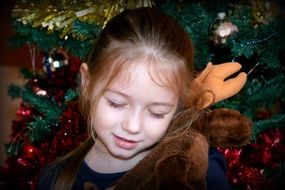 little girl with a gift near the Christmas tree
