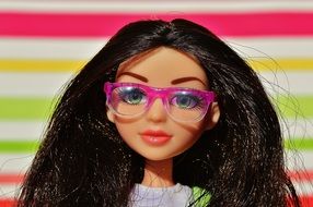 doll with black hair and glasses with a pink rim