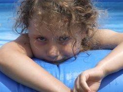 girl with curly hair in swimming pool