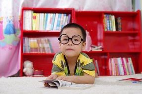 small boy in glass with book