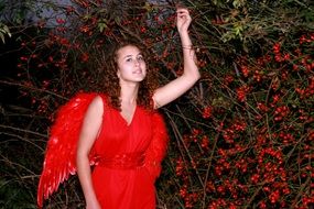 girl like a red angel among red berries