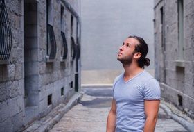 a man stands near a stone building