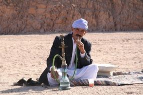 man with a hookah in the desert in India