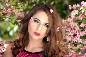 portrait of pretty woman on the flowering bush background