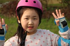 child in pink helmet in the park close-up