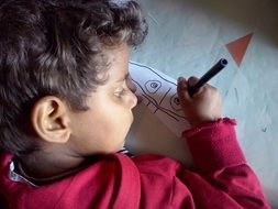 Indian child draws a pencil