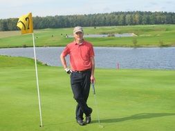 man in a red t-shirt on a golf course