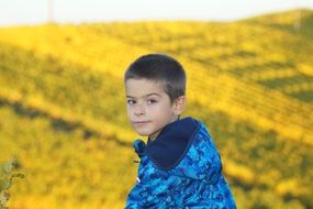 boy in a blue jacket on a green background