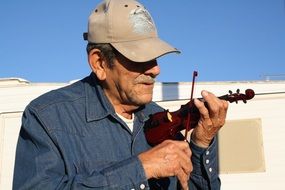 musician with a small violin on a city street