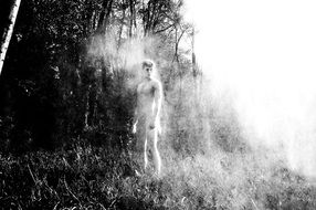 black and white photo of a ghost near the trees