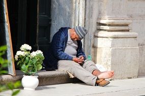 barefoot old man sleeps at Church, italy, Rome