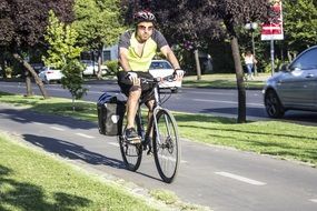 young Man riding Bicycle on street of summer town