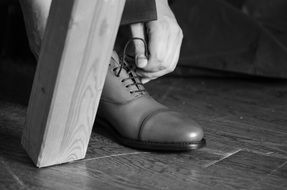 man lacing up his shoelaces